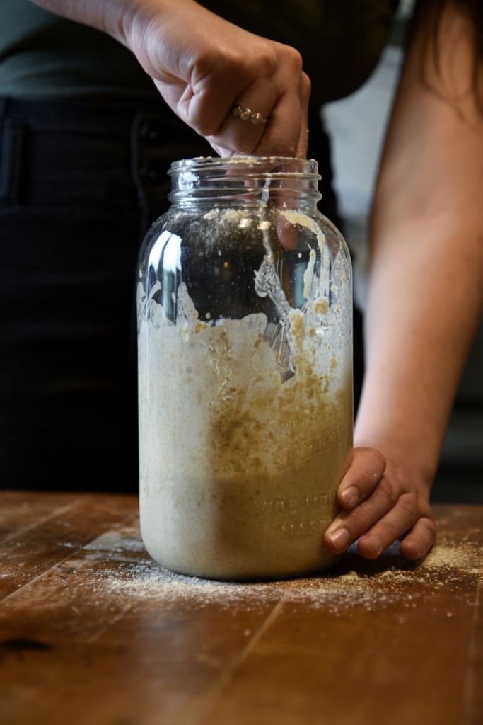 stirring a jar of sourdough starter