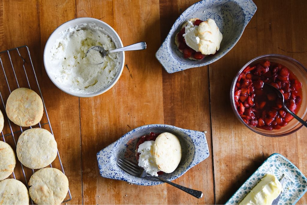 two finished strawberry shortcakes, with the ingredients around it 