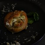 a pretzel on a plate that has been broken in half to show the filling