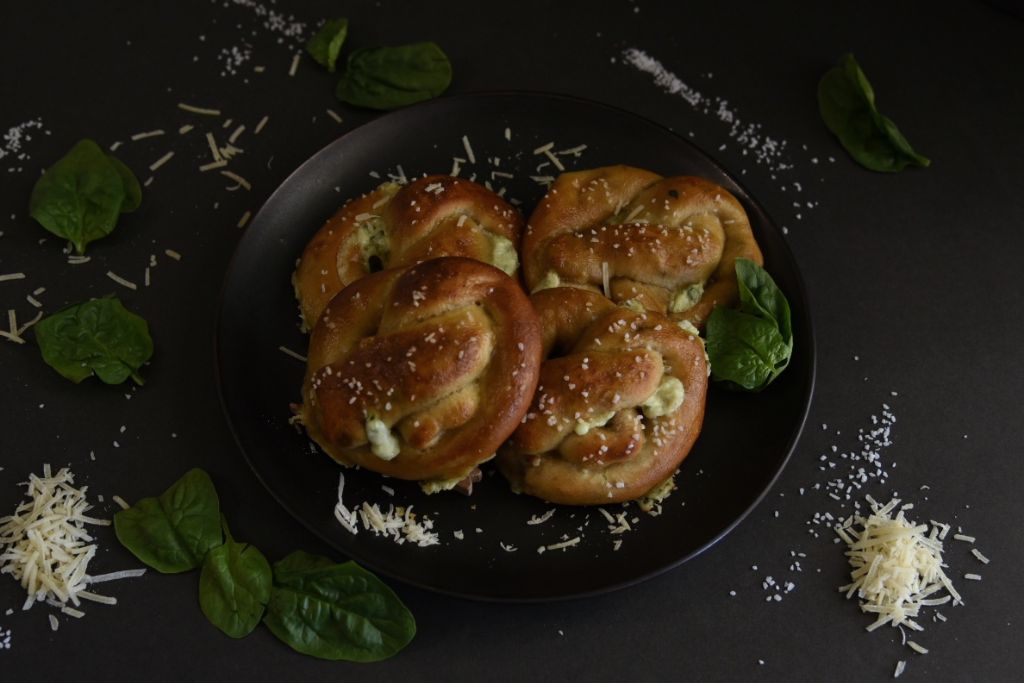 pretzels on plate with spinach cheeses and salt around them