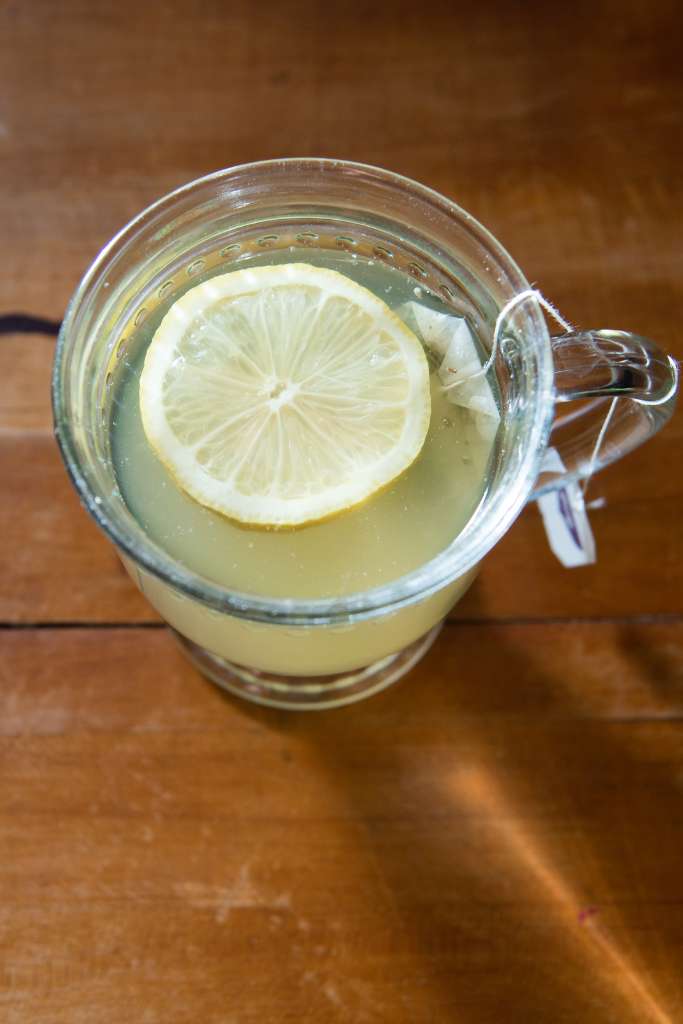 a cup of cold-fighting tea with a lemon slice in it