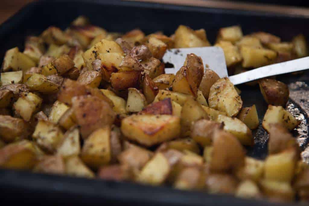 a pan of potatoes with a spatula in it 