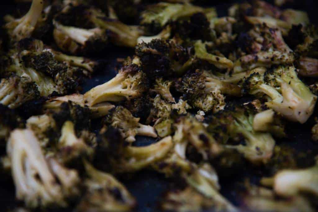 a close up picture of broccoli florets on a baking sheet
