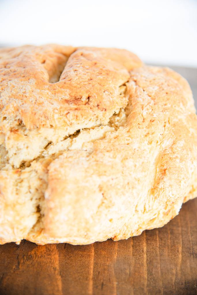 a loaf of soda bread on a wooden cutting board 