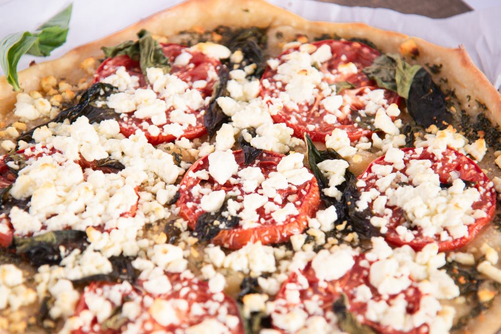 an overhead shot of finished feta and basil pizza 